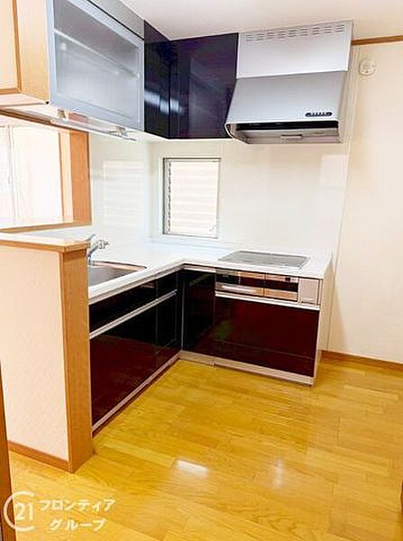 効率よくお料理ができるL字型のシステムキッチンです　深みのあるカラーが空間を引き締め落ち着いた雰囲気の中で家事を楽しめます　窓からの自然光が手元を明るく照らしてくれる設計も嬉しいポイントです