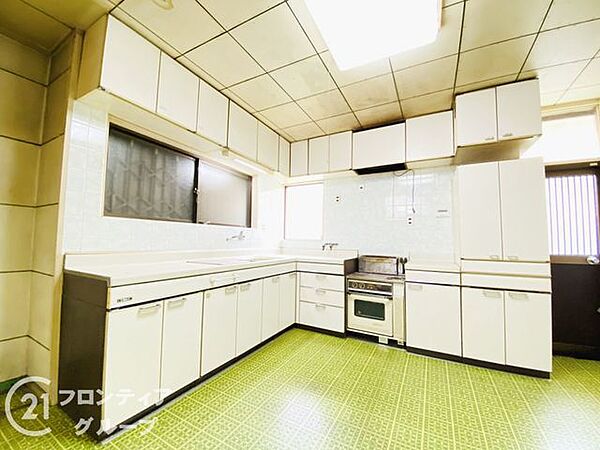 白を基調とした清潔感あふれるキッチンです。窓からの自然光が手元を明るく照らすので、日々の料理も捗りますね。広々とした調理スペースで、ご家族との会話を楽しみながら美味しい食事を作ってください