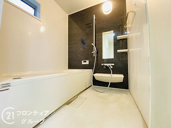 清潔感のある白とシックな壁面のコントラストがとても素敵ですね！広々とした洗い場と機能的なシャワーヘッドが完備されており、心身ともにリフレッシュできる極上の癒やし空間ですね！