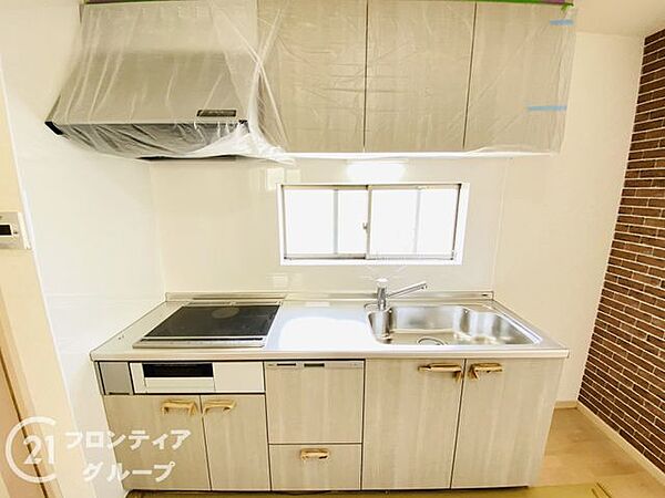 明るい木目調のパネルが印象的なシステムキッチンです。手元を明るく照らす窓があり、換気もしやすく清潔感を保てます。毎日の料理の時間がもっと楽しくなるような工夫が随所に施されています