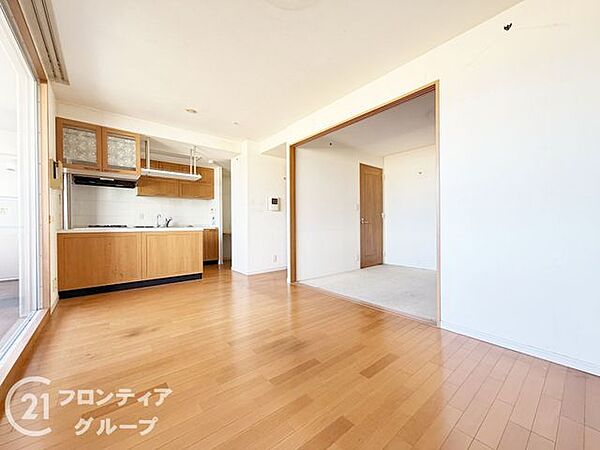 温もりあふれる木目調のフローリングが美しい広々としたリビングです。キッチンからお部屋全体を見渡せる開放的な設計で、家族との会話も自然と弾みます。充実のサービスが揃う憧れのマンションライフがここから始…