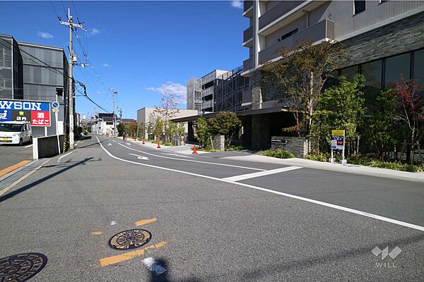 敷地西側の前面道路。周辺は一部店舗や事務所、主に戸建やアパートが並ぶ住宅地です。