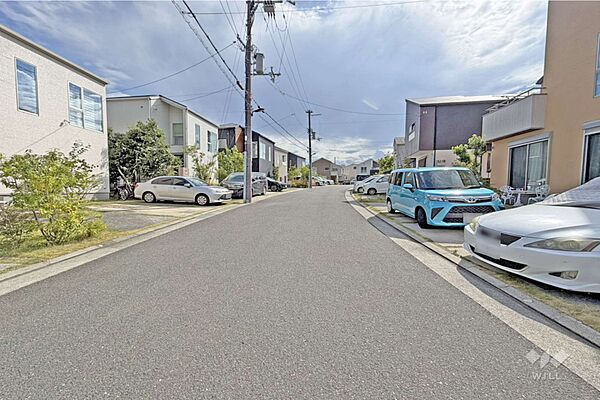 物件の南東側前面道路（北東側から）［2026年7月26日撮影］ニュータウン内！周辺は戸建てが立ち並ぶ住宅地です。周囲を緑地に囲まれ、自然豊かな住環境！