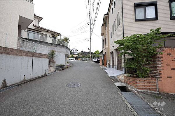 物件の北西側前面道路（南西側から）周辺は主に集合住宅と一戸建てが立ち並ぶ住宅地です。［2026年6月23日撮影］