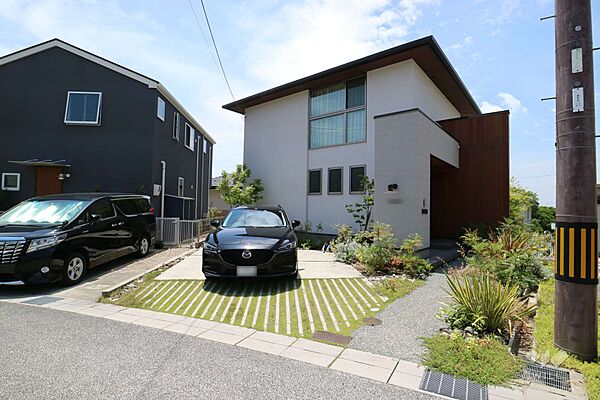 外観です。駐車2台可能なスペースがあります。植栽がきれいに整えられています。東と西の両面道路です。