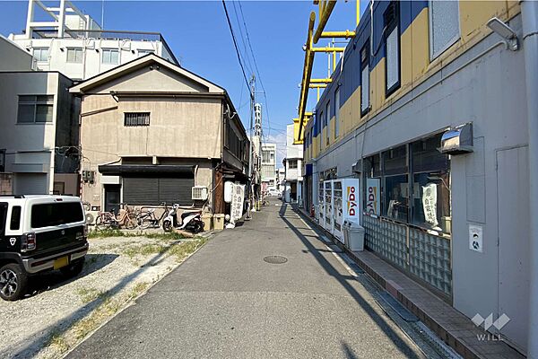 物件の南側前面道路（西側から）［2025年8月1日撮影］。阪急宝塚線「庄内」駅徒歩2分。敷地面積約31.7坪。建築条件なし土地。お好きなハウスメーカー、工務店で建物建築が可能です。