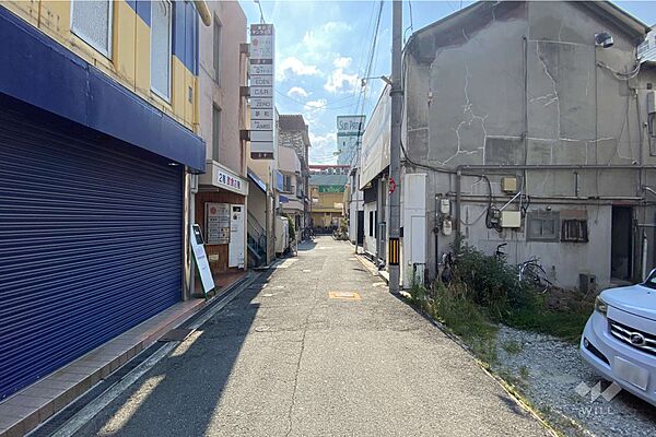 物件の南側前面道路（東側から）［2025年8月1日撮影］。阪急宝塚線「庄内」駅徒歩2分。敷地面積約31.7坪。建築条件なし土地。お好きなハウスメーカー、工務店で建物建築が可能です。