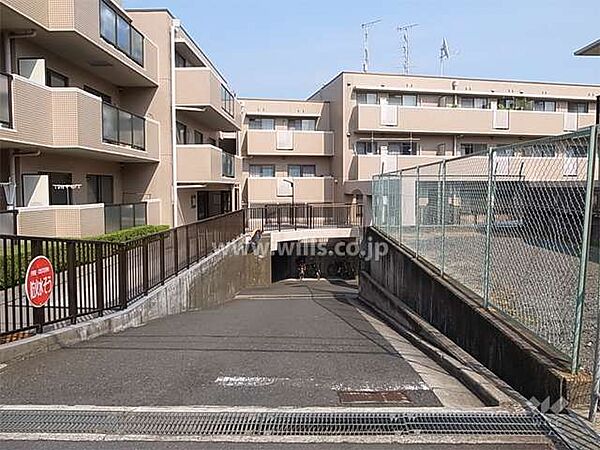 駐車場へのアプローチ。阪急宝塚線「豊中」駅徒歩17分。1989年6月築。総戸数67戸の分譲マンションです。