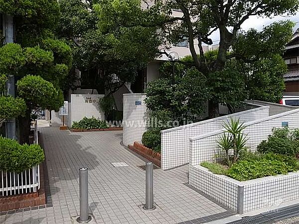 エントランスアプローチ（スロープ付き）。阪急宝塚線「庄内」駅徒歩15分。1984年5月築。総戸数58戸の分譲マンションです。