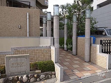 エントランスアプローチ。北大阪急行線「千里中央」駅徒歩9分。1998年7月築。総戸数9戸の分譲マンションです。