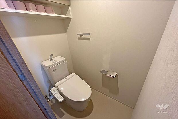 【トイレ】一面ホワイトの清潔感溢れる個室空間です。トイレットペーパーホルダーの上に携帯などを少し置くこともできます。