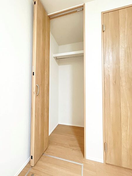 衣類収納に便利なハンガーパイプと棚を備えたクローゼット。空間をすっきりと保ちます。