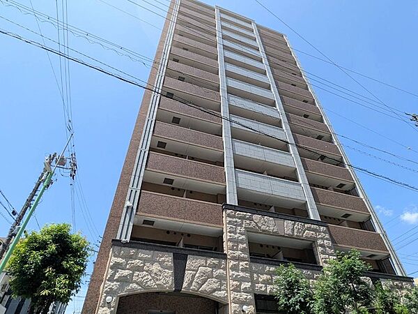 青空に映える外観が印象的なマンションです。落ち着いた色合いのタイルと石張りのエントランスが、洗練された雰囲気を演出しています。