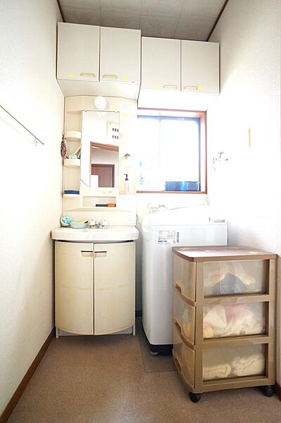 シャワー付洗面洗面台の横には洗濯機もしっかり置けて、たっぷり収納棚付き