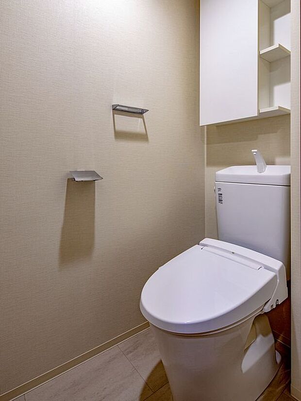 白を基調とした清潔感あふれるトイレです。掃除用品やトイレットペーパーをすっきりと収納していただけます