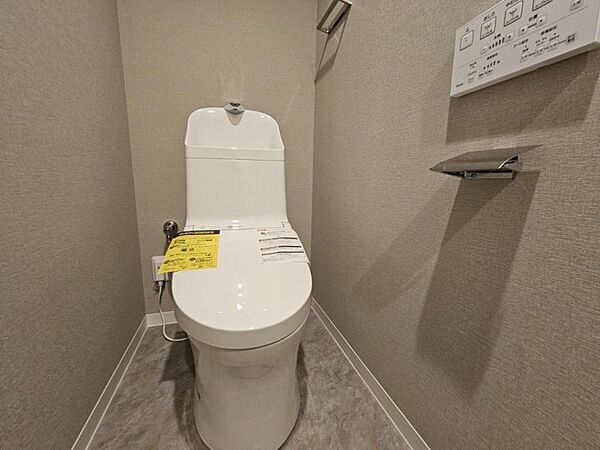 落ち着いたカラーの壁紙のトイレです