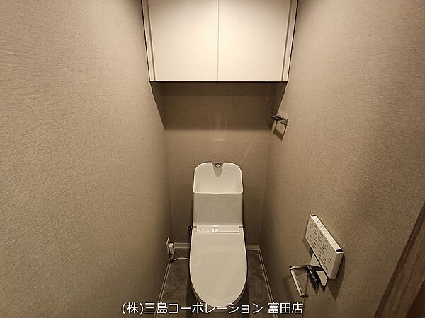 落ち着いた色合いの壁紙が心地よい空間を演出します。吊り戸棚は収納力があり、空間をすっきりと保てます。