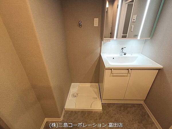 明るい照明が印象的な洗面台。すっきりとしたデザインで、日々の身支度を快適にサポートします。洗面台下には収納スペースも確保されています。