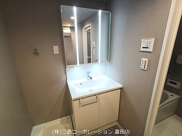 三面鏡付き洗面台で、毎日の身支度もスムーズに。収納スペースも確保され、使い勝手の良い洗面所です。