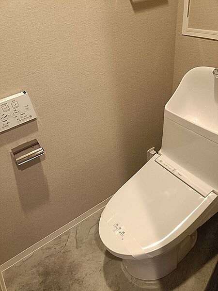 温水洗浄便座付きのトイレは、日々の快適さをサポートします。落ち着いた色合いの壁紙と床材が、穏やかな空間を演出。清潔感のある空間で、心地よいひとときをお過ごしください。