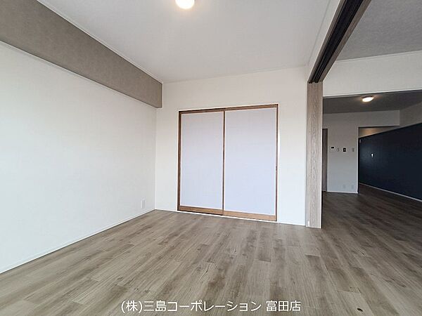 シンプルな内装に、木目調の床材とアクセントクロスが映える居室です。収納も備え付けられており、すっきりとした空間を保てます。