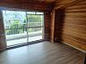 その他：温もりを感じる木目調の壁が特徴の居室。大きな窓から光が差し込み、明るく開放的な空間です。