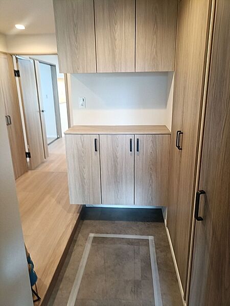 落ち着いた木目調の玄関収納は、機能的でありながら洗練された印象を与えます。毎日のお出かけをスムーズに。