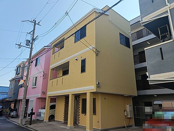 鮮やかな外観が目を引く3階建ての建物です。駐車スペースも確保されており、都市での生活をサポートします。