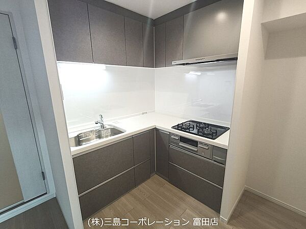落ち着いた色合いのシステムキッチンは、お料理を楽しくサポート。充実した収納スペースも魅力です。