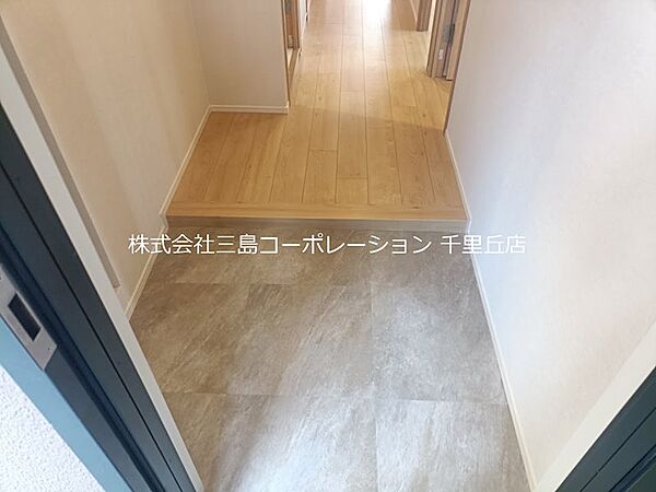 温かみのある木目調の床と、落ち着いた色合いの玄関フロアが訪れる人を優しく迎え入れます。清潔感あふれる空間が、日々の暮らしに心地よさをもたらします。