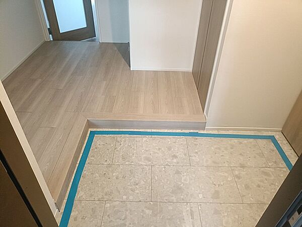 明るい木目調のフローリングが広がる玄関。開放的な空間がお客様をお迎えします。