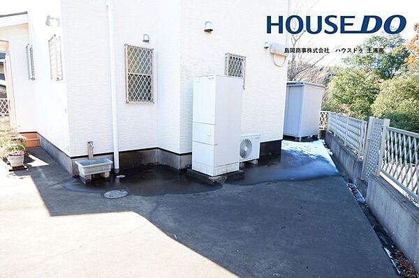 建物北側の写真♪フェンス側に傾斜地にいけるドアがございます！こちらもコンクリート舗装になっております。