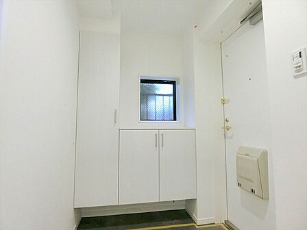 玄関にはご家族皆様の靴を収納できる収納スペースを設けました。窓付きの明るい玄関です。
