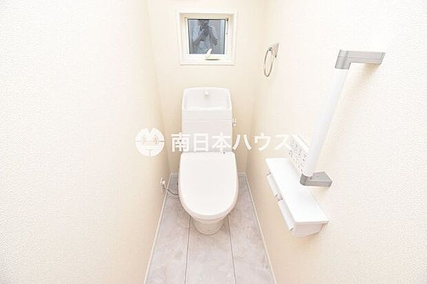 清潔感のある明るいトイレ。窓から自然光を取り込め、手すりも備えています。