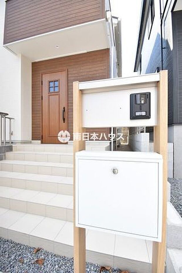 木目調の玄関ドアが温かみのある印象。宅配ボックス付きで、不在時の荷物の受け取りにも便利です。