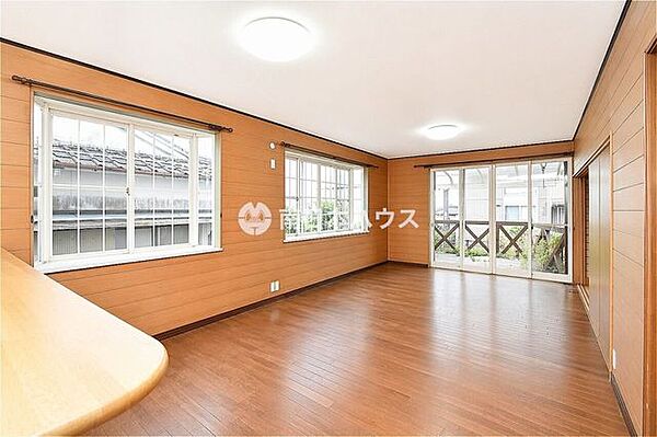 木目調の内装があたたかみを感じさせるリビングです。大きな窓があり、室内の広さや開放感が伝わります。