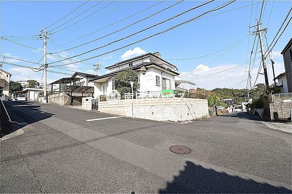 開放感のある角地に建つ住まいです。建物と道路の位置関係が分かり、現地の雰囲気や街並みも伝わります。