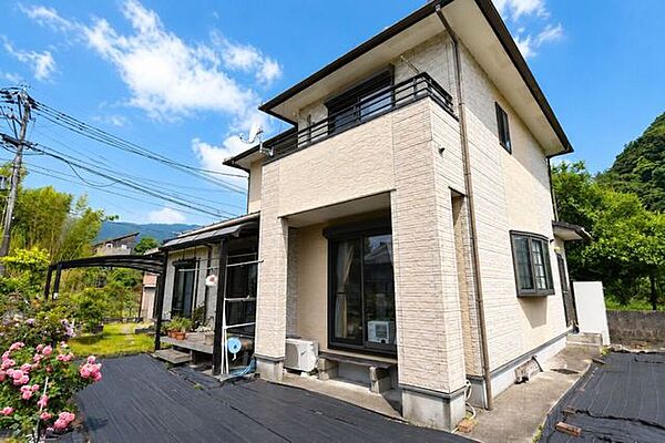 建物の佇まいと周辺の緑が調和する外観カット。落ち着いた住環境が感じられます。