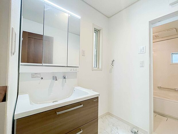 洗面室は窓の光が差し込み明るく清潔感があります。三面鏡は朝の支度が大助かり。