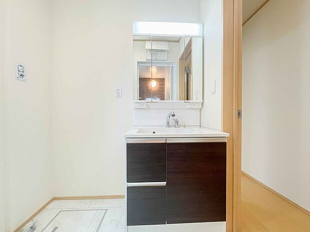 洗面室は窓の光が差し込み明るく清潔感があります。三面鏡は朝の支度が大助かり。