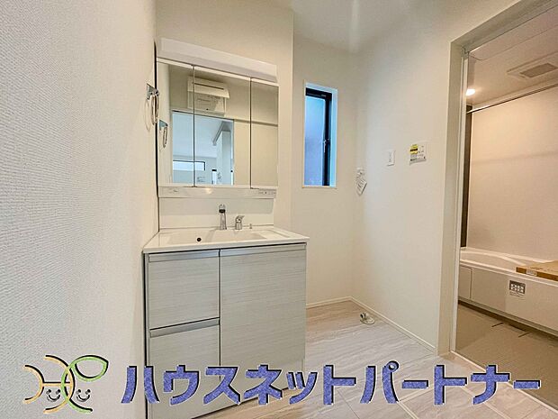 三面鏡洗面化粧台。ミラーを手前に引けば、楽な姿勢で髭剃りやメイクができます。合わせ鏡にすればヘアスタイルのチェックもラクラク。洗面化粧台のミラー裏にはたっぷり入る収納スペースを設けています。　