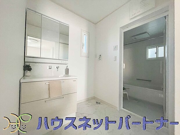 三面鏡洗面化粧台。ミラーを手前に引けば、楽な姿勢で髭剃りやメイクができます。合わせ鏡にすればヘアスタイルのチェックもラクラク。洗面化粧台のミラー裏にはたっぷり入る収納スペースを設けています。　