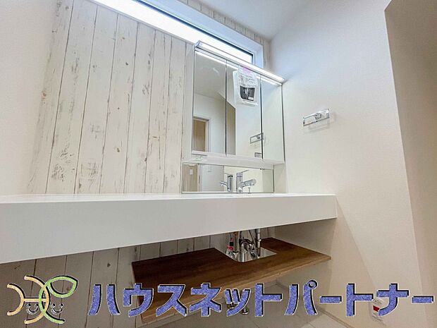 三面鏡洗面化粧台。ミラーを手前に引けば、楽な姿勢で髭剃りやメイクができます。合わせ鏡にすればヘアスタイルのチェックもラクラク。洗面化粧台のミラー裏にはたっぷり入る収納スペースを設けています。