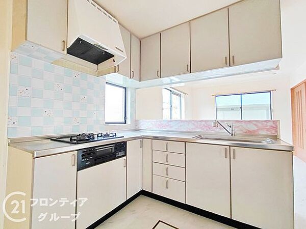 白を基調とした清潔感のあるL型キッチンは、作業スペースが広くお料理が捗ります。窓からの自然光が手元を明るく照らし、毎日の家事時間を心地よいものに変えてくれます