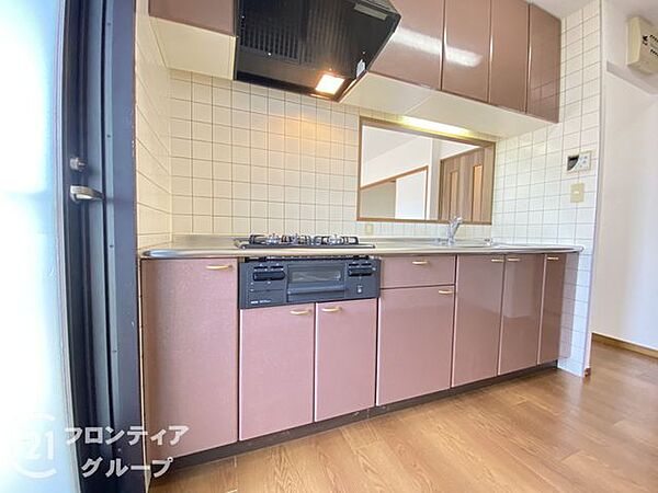 柔らかな光が差し込む窓付きのキッチンは、お料理中も開放的な気分で過ごせる機能的な空間です。上品な色合いのキャビネットがインテリアに華を添え、効率的な動線で毎日の家事もスムーズにこなせます