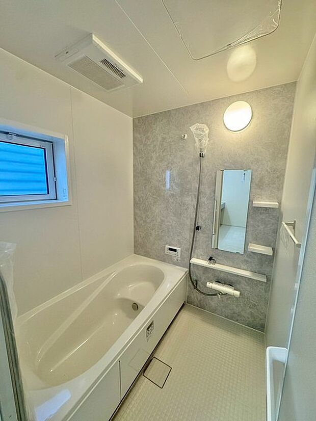 浴室乾燥機付ユニットバス。落ち着いた雰囲気が漂い、リラックスできる贅沢なバスタイムを提供します。