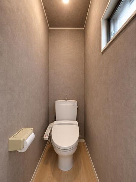 落ち着いたアクセントクロスが上質な雰囲気を演出する、シンプルで清潔感のあるトイレ空間。（CG加工を使用しております。）