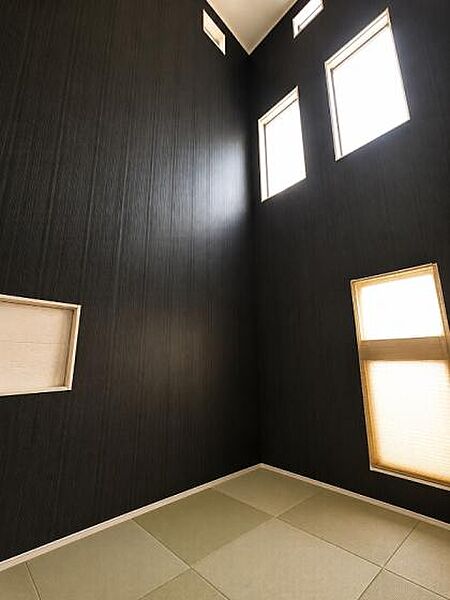 天井まで伸びる吹抜け空間に、複数の窓からやわらかな自然光が差し込む開放感あふれる和室。
