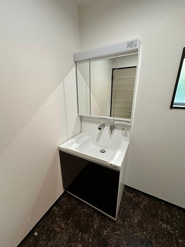 床の汚れ等も目立ちにくいブラックカラーを採用した洗面室。サイド物置スペースのある機能性のある洗面台です。