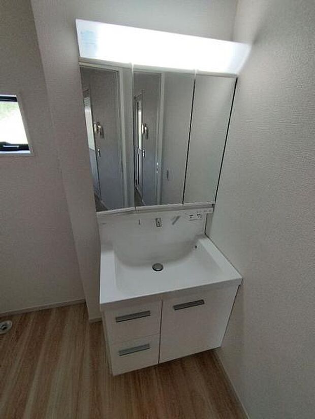 1号棟 人気の三面鏡タイプの洗面台です。鏡の裏にも棚があるので収納豊富です。